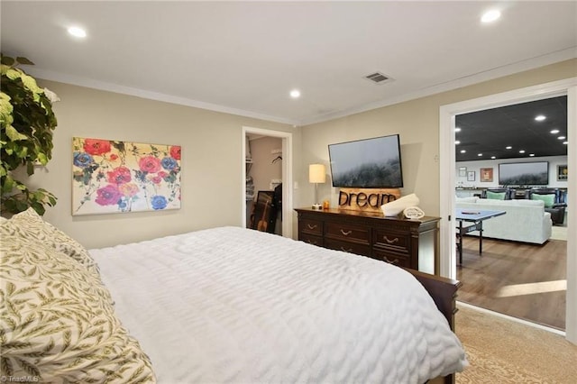 bedroom featuring a walk in closet, a closet, and crown molding