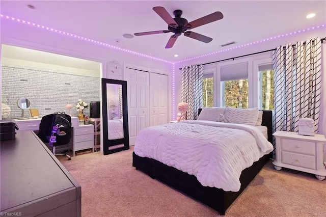 bedroom with ceiling fan, light carpet, and a closet