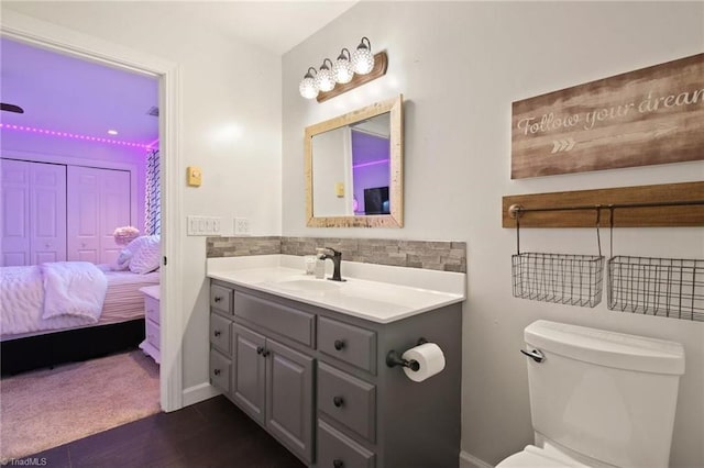 bathroom featuring backsplash, toilet, and vanity