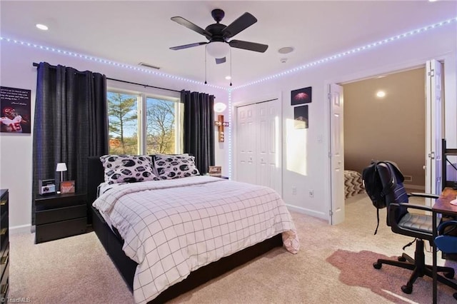 bedroom with ceiling fan, light colored carpet, and a closet