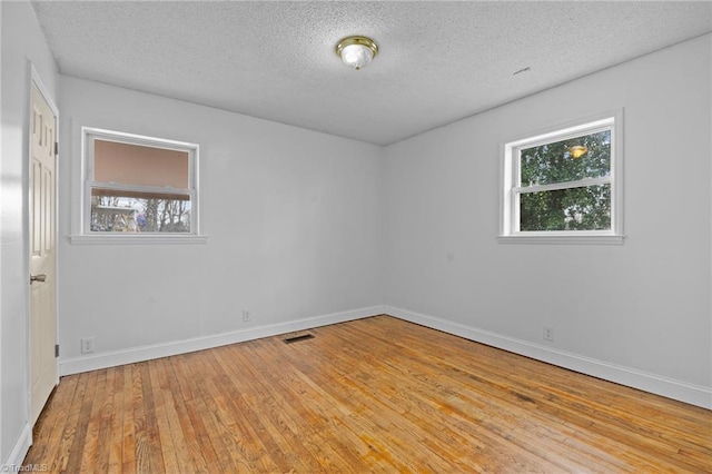 empty room featuring light hardwood / wood-style floors and a textured ceiling