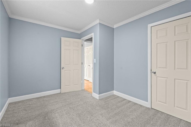 unfurnished bedroom featuring ornamental molding, light colored carpet, and a textured ceiling