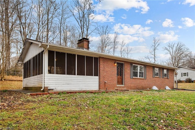 single story home featuring a sunroom and a front yard