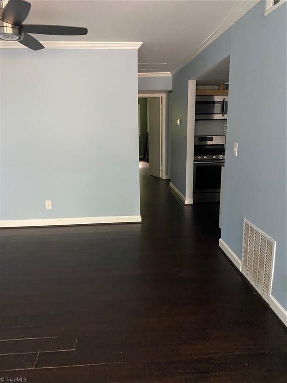 2821 Bleeker Sq Unit E, Winston-Salem, NC 27106 - unfurnished room featuring crown molding, ceiling fan, dark wood-style floors, and baseboards