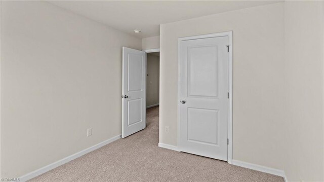 3765 Baden Rd, Winston-Salem, NC 27107 - unfurnished bedroom with baseboards and light carpet