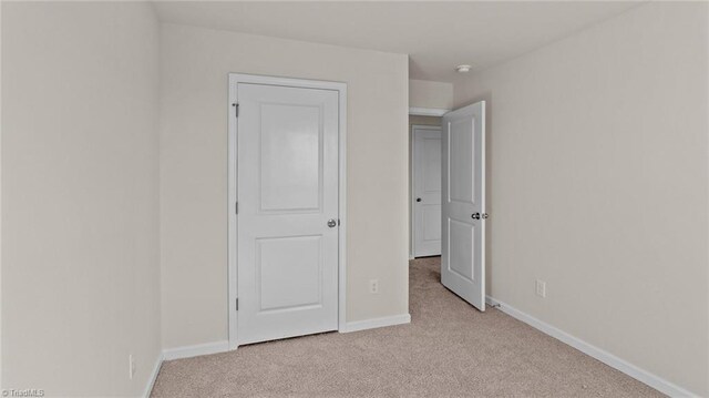 3765 Baden Rd, Winston-Salem, NC 27107 - unfurnished bedroom with baseboards and light colored carpet