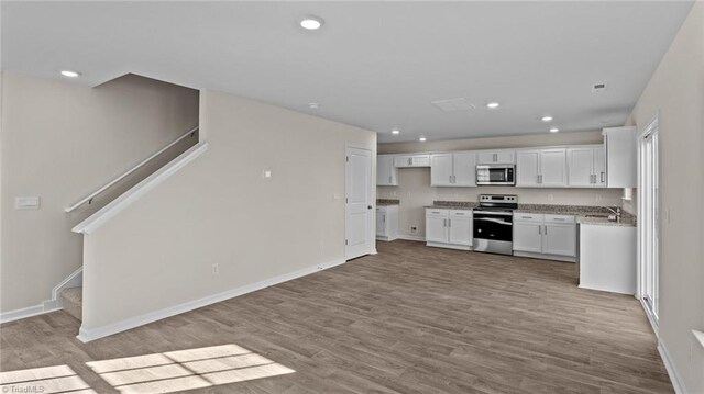 3765 Baden Rd, Winston-Salem, NC 27107 - kitchen featuring wood finished floors, baseboards, recessed lighting, white cabinetry, and stainless steel appliances