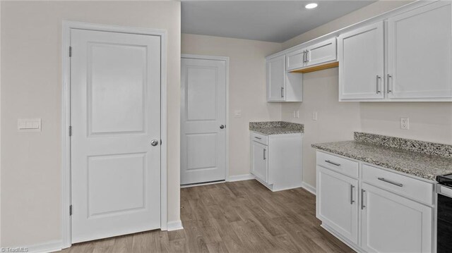 3765 Baden Rd, Winston-Salem, NC 27107 - kitchen with light stone countertops, wood finished floors, baseboards, white cabinets, and recessed lighting
