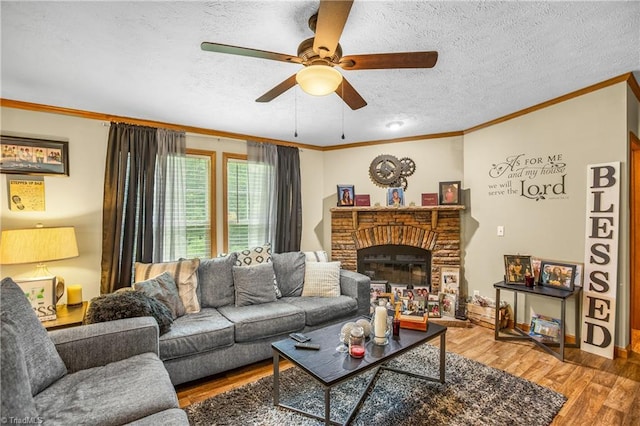 1030 Endeavour Ln, Walnut Cove, NC 27052 - living area featuring ornamental molding, wood finished floors, a ceiling fan, a textured ceiling, and a fireplace