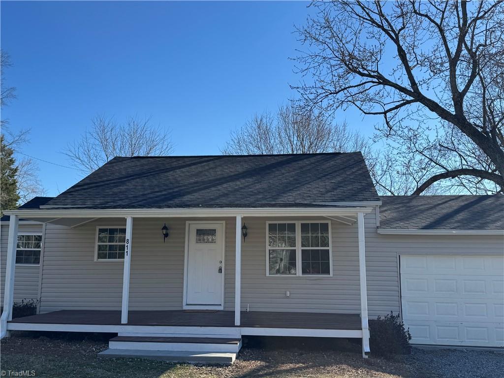 view of front of house with a porch, roof with shingles, and an attached garage