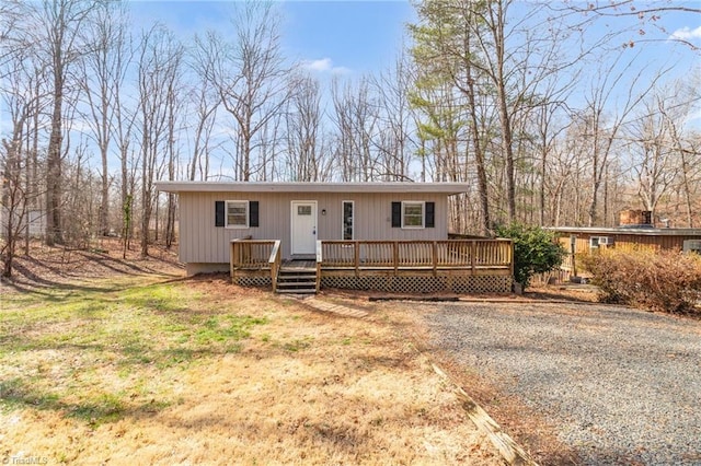 view of front of property featuring driveway and a deck