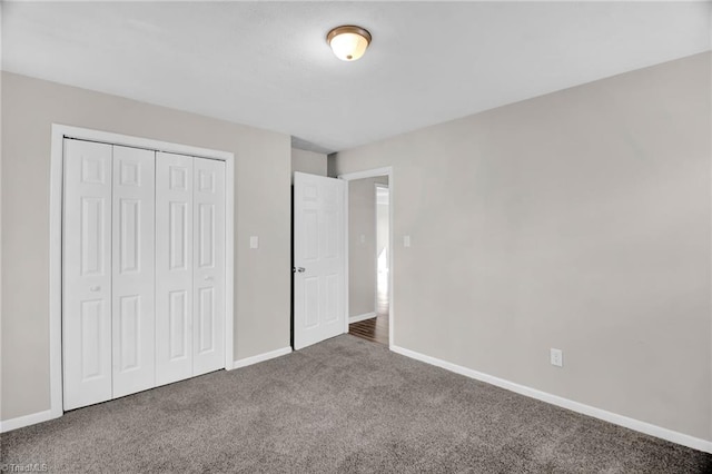 unfurnished bedroom with carpet, a closet, and baseboards