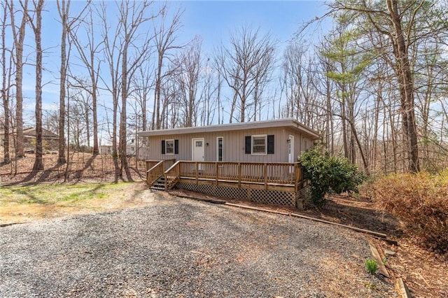 view of front of property featuring gravel driveway and a deck