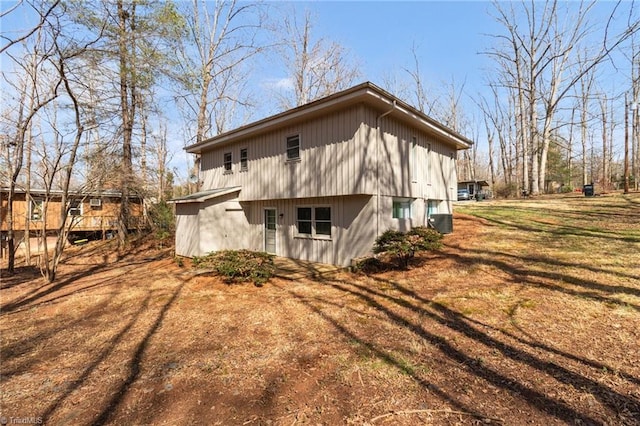 back of property featuring a lawn and central AC unit