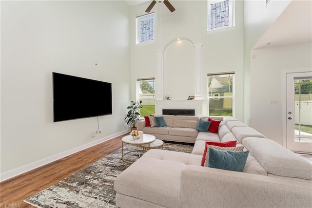 2452 Tannin Ct, High Point, NC 27265 - living area featuring a towering ceiling, wood finished floors, a ceiling fan, and a fireplace