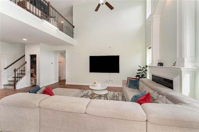 2452 Tannin Ct, High Point, NC 27265 - living room with a towering ceiling, stairs, decorative columns, and wood finished floors
