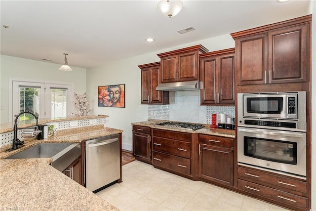 2452 Tannin Ct, High Point, NC 27265 - kitchen featuring stainless steel appliances, under cabinet range hood, light stone counters, backsplash, and pendant lighting
