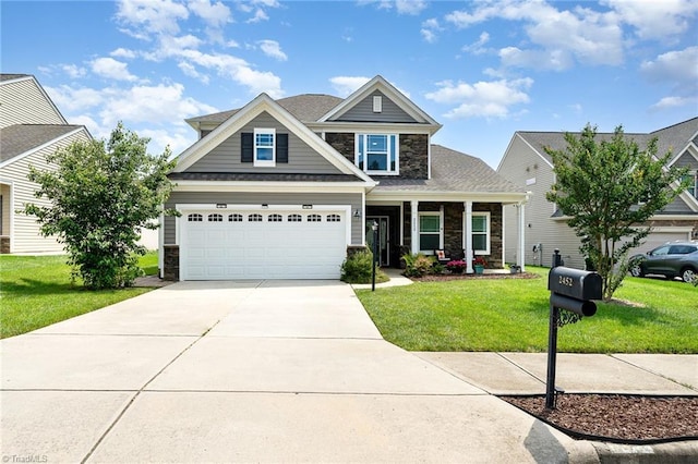 2452 Tannin Ct, High Point, NC 27265 - view of front of home with stone siding, driveway, a front yard, a garage, and covered porch