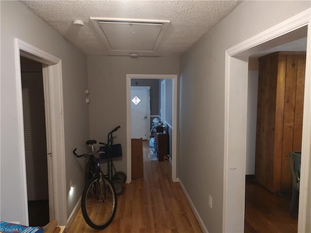 hall with dark hardwood / wood-style flooring and a textured ceiling