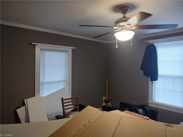 bedroom with wooden walls, ceiling fan, and crown molding