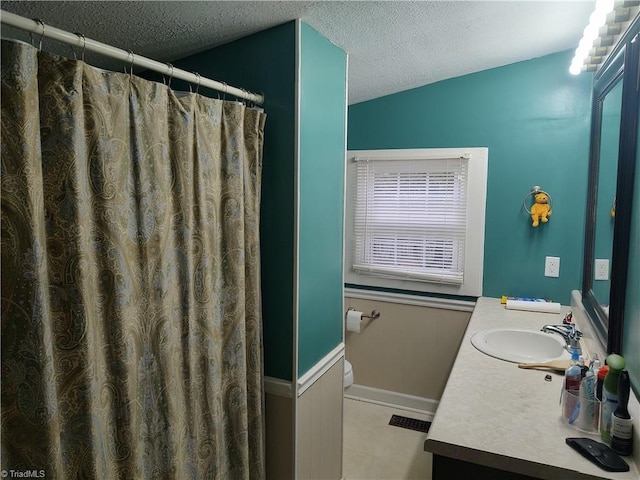 bathroom featuring curtained shower, vanity, a textured ceiling, and toilet