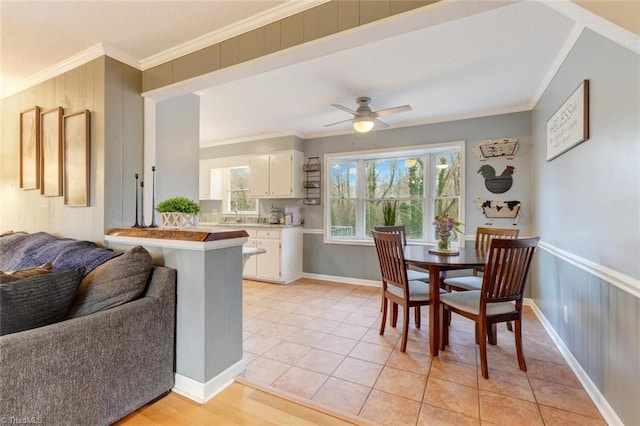 kitchen with white cabinetry, ornamental molding, light tile patterned floors, and kitchen peninsula