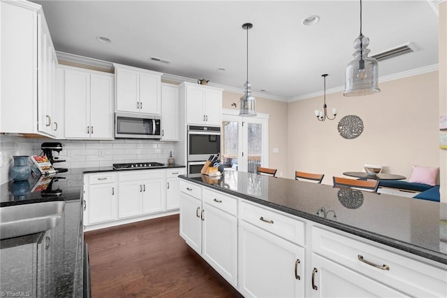 kitchen featuring white cabinets, stainless steel appliances, and pendant lighting