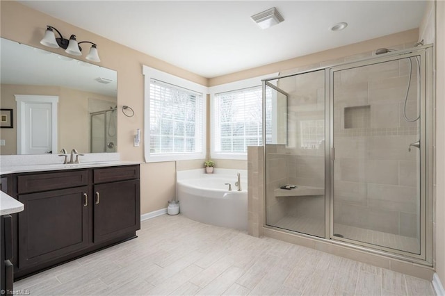 bathroom featuring separate shower and tub and vanity