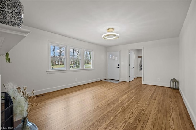 unfurnished living room featuring wood finished floors and baseboards