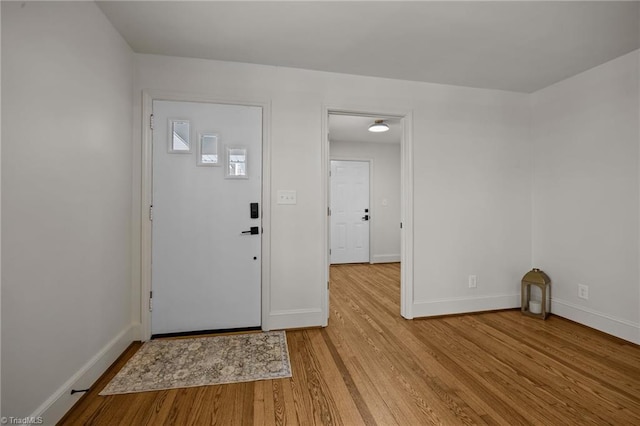 entrance foyer with baseboards and wood finished floors