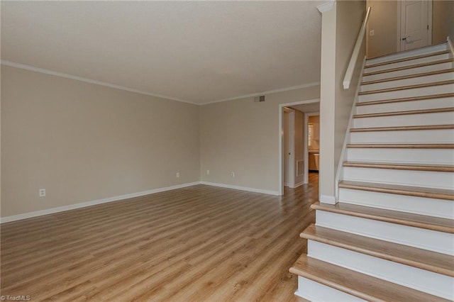 stairs with hardwood / wood-style flooring and crown molding