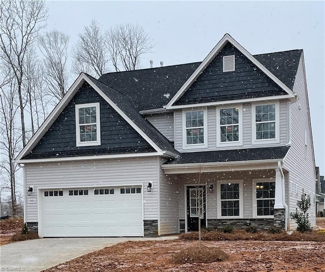 traditional home with a porch, concrete driveway, and a garage