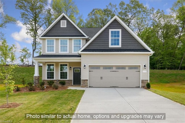 craftsman-style house with a front lawn, an attached garage, stone siding, and driveway