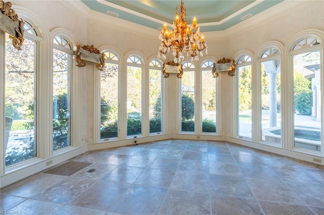 unfurnished sunroom featuring a notable chandelier and a tray ceiling