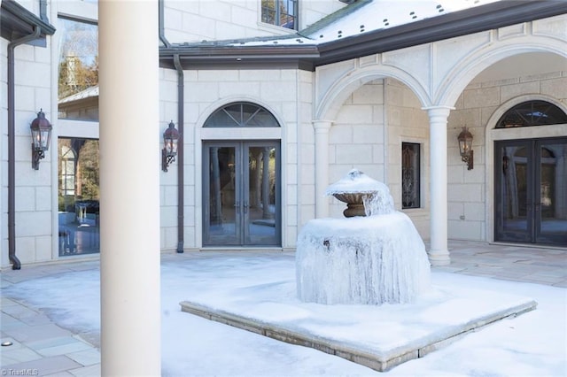 snow covered property entrance with french doors