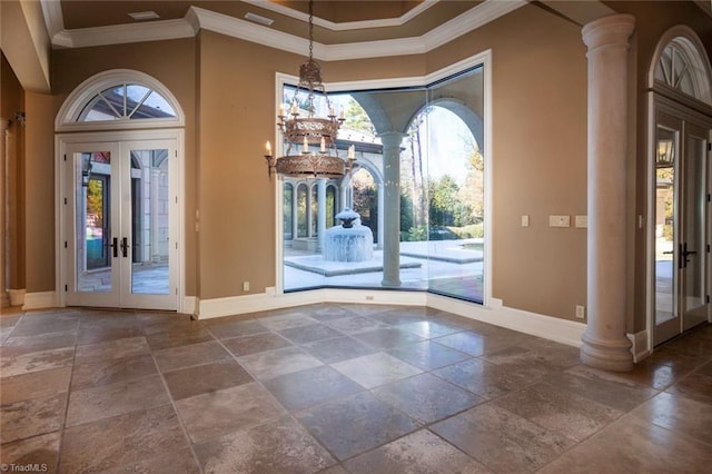 interior space featuring a towering ceiling, ornamental molding, french doors, and a healthy amount of sunlight