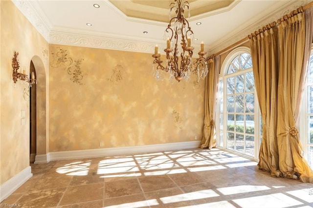 spare room featuring crown molding, a tray ceiling, and a notable chandelier