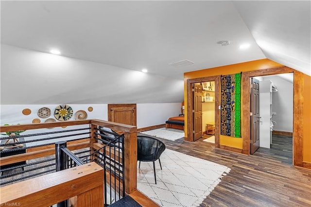 bonus room with dark wood-type flooring and vaulted ceiling