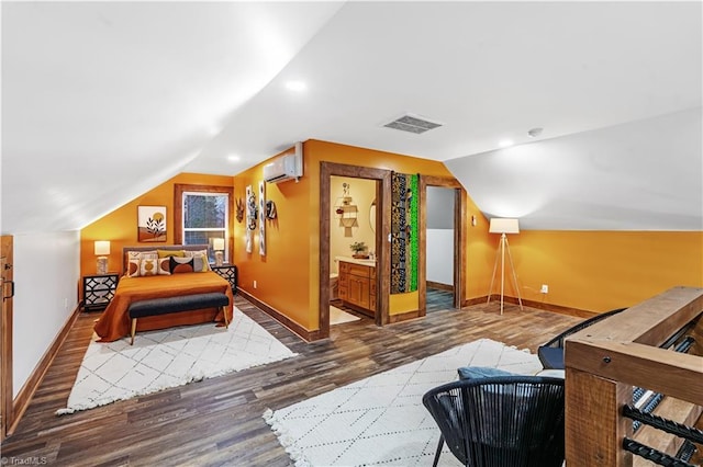 bedroom featuring ensuite bathroom, dark hardwood / wood-style flooring, vaulted ceiling, and a wall mounted air conditioner