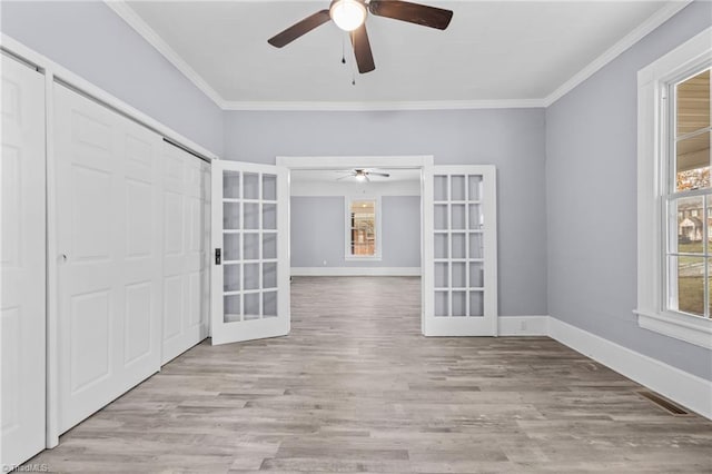 interior space featuring ceiling fan, light hardwood / wood-style floors, crown molding, and french doors