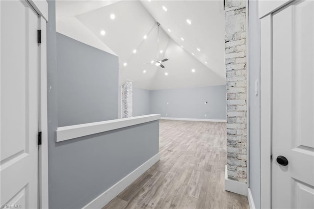 hall with light hardwood / wood-style floors and vaulted ceiling