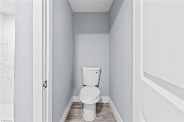 bathroom featuring wood-type flooring and toilet