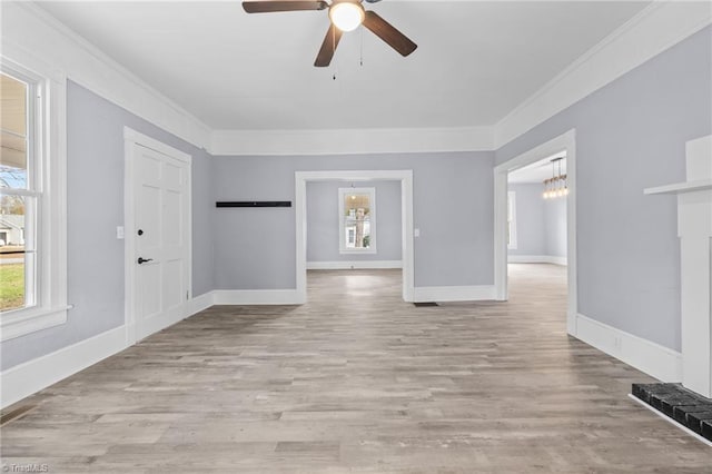 empty room featuring light hardwood / wood-style flooring, ceiling fan with notable chandelier, and ornamental molding