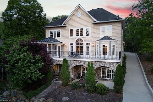338 Fairfield Ct, Mount Gilead, NC 27306 - back of property at dusk with a standing seam roof, french doors, metal roof, and stone siding