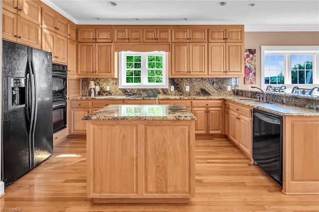 338 Fairfield Ct, Mount Gilead, NC 27306 - kitchen featuring black appliances, a sink, light wood-style flooring, light brown cabinets, and a kitchen island
