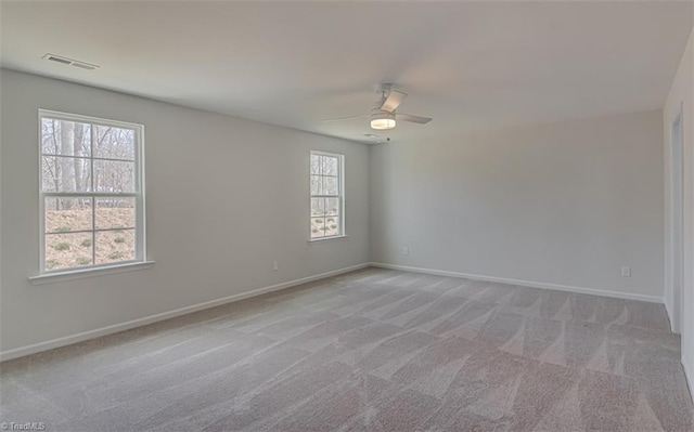 unfurnished room with baseboards, visible vents, a ceiling fan, and light colored carpet