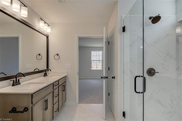 bathroom with marble finish floor, a sink, a shower stall, and double vanity