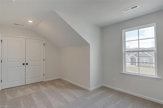 bonus room featuring plenty of natural light, visible vents, and light colored carpet