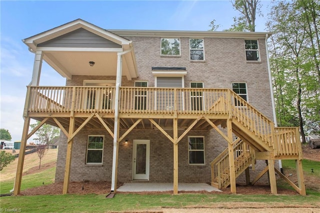 back of property with a wooden deck and a patio area