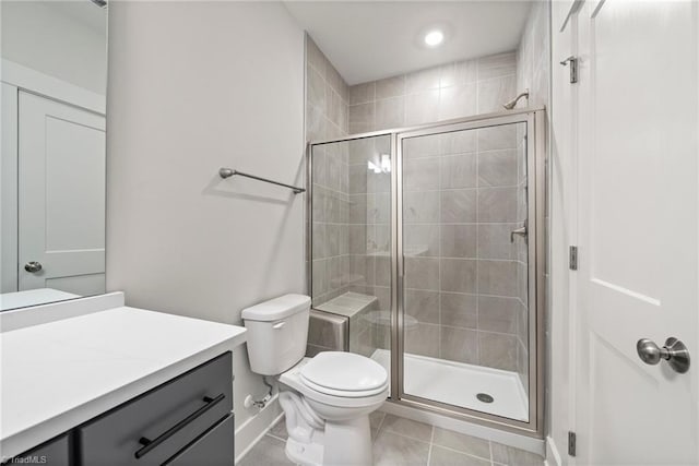 bathroom featuring toilet, tile patterned floors, a shower with door, and vanity